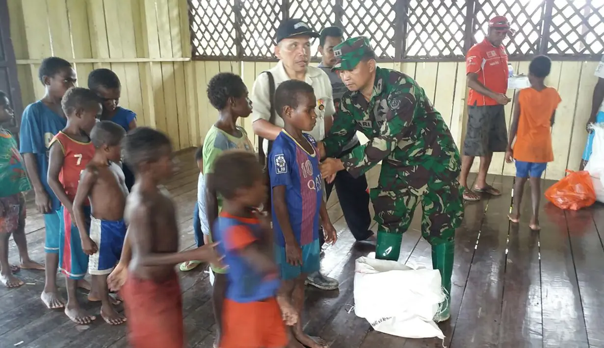 Personel Tim Gabungan Satgas Kesehatan TNI melakukan vaksin campak terhadap anak-anak di Kabupaten Asmat, Papua, Jumat (19/1). Personel Tim Kesehatan Gabungan Satgas akan fokus terhadap penanganan campak selama satu bulan. (LIputan6.com/Pool/Puspen TNI)