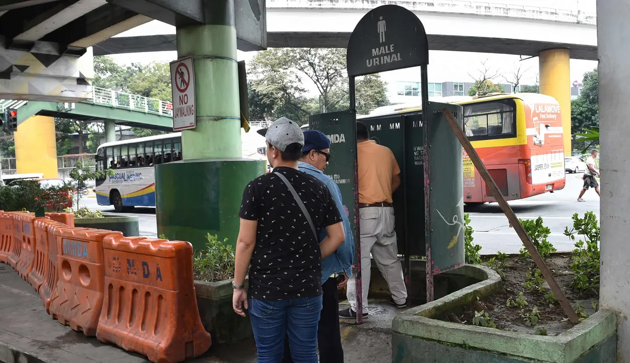 Warga mengantre menggunakan toilet umum di sepanjang jalan utama di Manila, Filipina, (24/11). Tidak seperti umumnya, toilet di Filipina ini dibangun di bawah jembatan dan berada di tempat terbuka. (AFP Photo/Ted Aljibe)