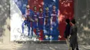 Fans melihat poster pemain Barcelona, Gerard Pique yang dirusak di sebuah toko yang ditutup sebagai bagian dari pemogokan oleh serikat pekerja Catalonia di luar stadion Camp Nou, Barcelona (3/10). (AFP Photo/Josep Lago)