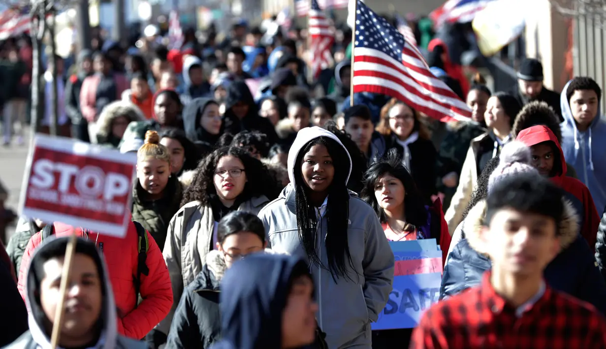 Sejumlah siswa dari James Ferris High School turun ke jalan melakukan aksi protes di Jersey City (14/3). Dengan membawa poster dan spanduk berukuran besar, para siswa menuntut Kongres agar berani mengambil tindakan lebih tegas. (AP Photo / Julio Cortez)