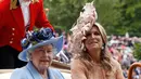 Ratu Inggris Elizabeth II (kiri) dan Ratu Belanda Maxima mengenakan topi atau fascinator unik saat menghadiri ajang pacuan kuda Royal Ascot di Ascot, Inggris, Selasa (18/6/2019). Royal Ascot menjadi ajang bagi wanita Inggris untuk tampil dengan fascinator unik. (AP Photo/Alastair Grant)