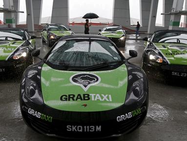 Sejumlah armada GrabTaxi yang terdiri dari tujuh mobil mewah disiapkan untuk pemotretan sebelum beroperasi di Singapura, Selasa (15/9). Mobil-mobil mewah itu akan melayani penumpang secara gratis selama musim balapan F1. (REUTERS/Edgar Su)