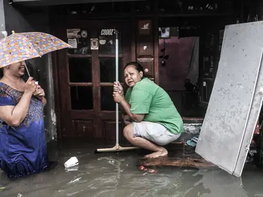 Warga berada di depan rumah saat banjir merendam permukiman Bukit Duri, Jakarta, Kamis (18/2/2021). Hujan deras yang mengguyur sejak pagi menyebabkan permukiman warga di 5 RW, yakni RW 03, 04, 05, 06, dan 07 Kelurahan Bukit Duri terendam banjir. (merdeka.com/Iqbal S Nugroho)