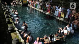Wisatawan antri membersihkan diri (melukat) di Pura Tirta Empul, Desa Tampaksiring, Gianyar, Bali, jumat (6/5/20222). Dalam sehari, lebih dari 2.000 wisatawan berkunjung ke obyek wisata spiritual i yang menjadi salah satu primadona di Pulau Bali ini. (merdeka.com/Arie Basuki)