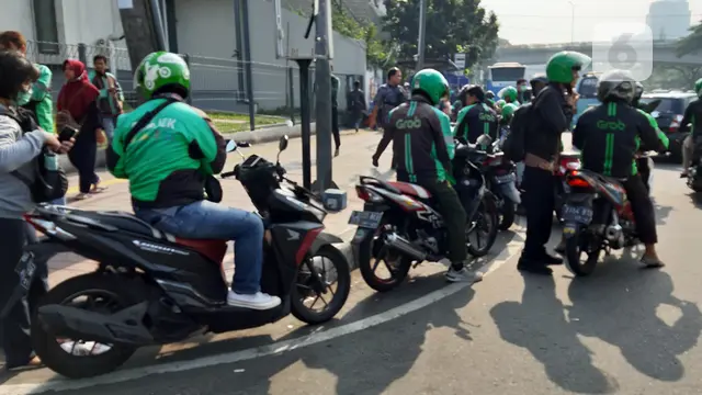 Driver ojek online (ojol) mengambil penumpang di dekat Stasiun Tanah Abang, Jakarta Pusat.