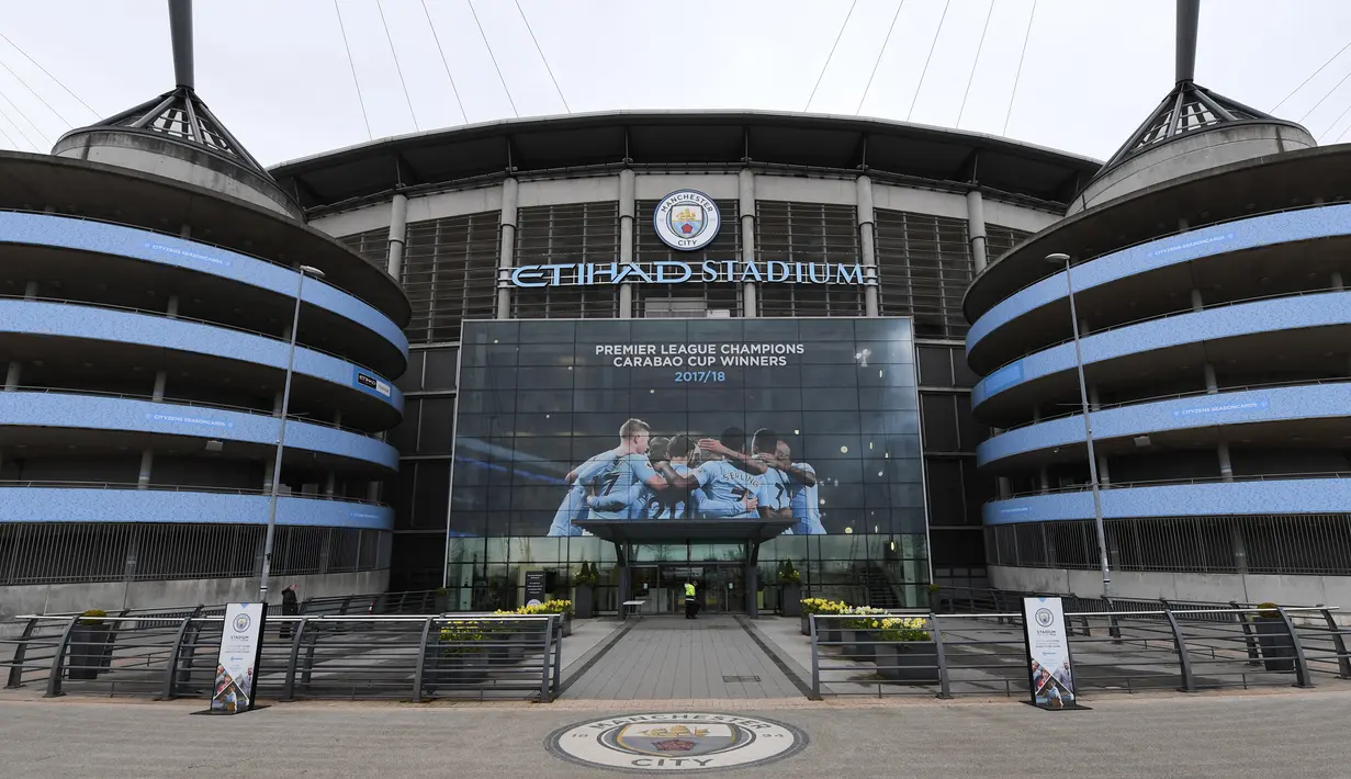 Poster raksasa bergambar pemain Manchester City terpasang di Stadion Etihad, Manchester, Senin (17/4/2018). Persiapan ini dilakukan untuk merayakan pesta juara Manchester City meraih gelar Premier League. (AFP/Paul Ellis)