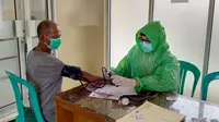 Paramedis Puskesmas Leuwiliang Bogor menggunakan jas hujan plastik untuk mencegah penyebaran virus corona Covid-19. (Rasyid Ali/Merdeka.com)