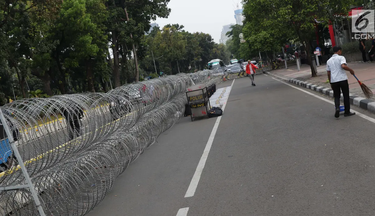 Kawat berduri terpasang di sebagian ruas Jalan Medan Merdeka Barat depan Gedung Mahkamah Konstitusi, Jakarta, Kamis (13/6/2019). Sekitar 12.000 pesonel gabungan akan menjaga sidang Perselisihan Hasil Pemilihan Presiden/Wakil Presiden Pemilu 2019. (Liputan6.com/Helmi Fithriansyah)