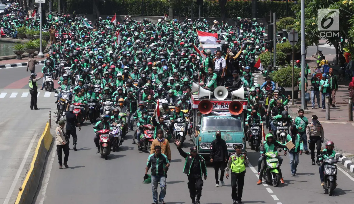 Petugas mengawal ribuan pengemudi ojek online di Jalan Medan Merdeka Barat, Jakarta, Selasa (27/3). Mereka bergerak dari IRTI Monas menuju seberang Istana Merdeka untuk menuntut Pemerintah melakukan rasionalisasi tarif. (Liputan6.com/Arya Manggala)