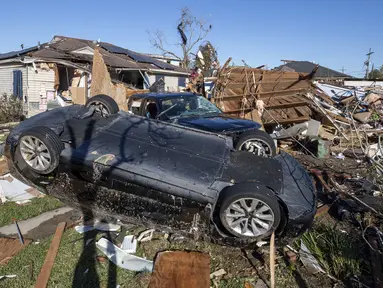 Sebuah Tesla duduk terbalik setelah tornado membalik mobil itu berada di jalan masuk rumah keluarga Harris di Tita Street di Algiers, sebuah lingkungan di New Orleans, Kamis (15/12/2022). Setidaknya tiga orang tewas dan belasan lainnya terluka akibat serangkaian tornado melanda New Orleans dan bagian lain di negara bagian Louisiana, Amerika Serikat. (David Grunfeld/The Times-Picayune/The New Orleans Advocate via AP)