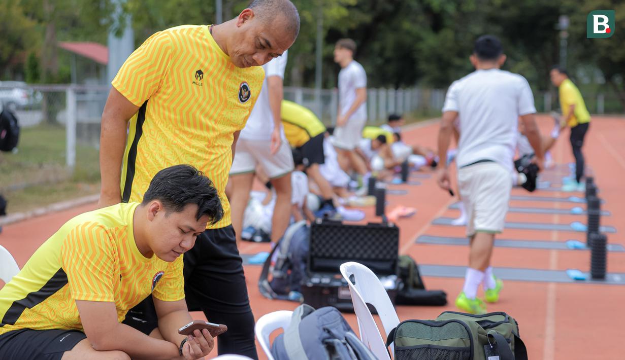 Selain Sumardji, asisten pelatih Timnas Indonesia U-22, Eko Purdjianto, juga menyaksikan laga Timnas Vietnam U-22 vs Timnas Malaysia U-22 dari layar handphone. (Bola.com/Bagaskara Lazuardi)