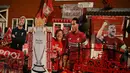 Penggemar Liverpool Emily Farley duduk di luar rumahnya, dihiasi dengan spanduk Liverpool dan cut out saat ia menunggu hasil pertandingan antara Manchester City dan Chelsea, di Liverpool, Inggris (25/6/2020). (AFP Photo/Oli Scarff)