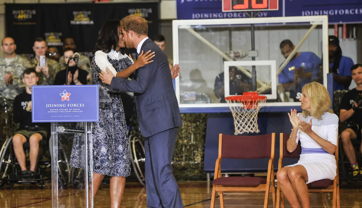 Michelle Obama  menyapa Pangeran Harry saat menghadiri sebuah acara di Fort Belvoir, Virginia, Rabu (28/10). Pertemuan ini diadakan untuk mendukung pelaksanaan Invictus Games Orlando 2016 kepada para tentara yang terluka. (AFP PHOTO/SAUL Loeb)