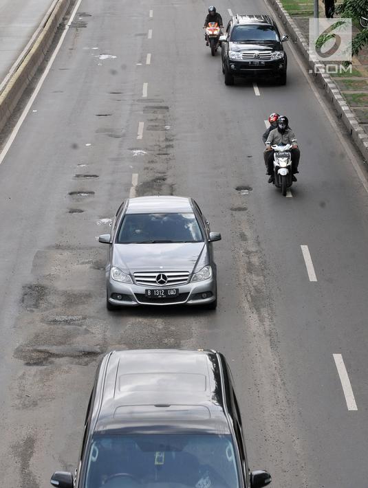 Kendaraan melintasi jalan berlubang di kawasan Gunung Sahari, Jakarta, Selasa (29/1). Jalan rusak dan berlubang di sepanjang Jalan Gunung Sahari tersebut dapat membahayakan pengendara yang melintas. (Merdeka.com/Iqbal S. Nugroho)