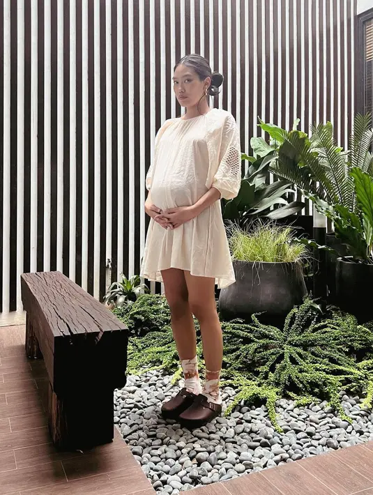 Untuk yang ingin tampil dengan dress longgar, bisa tetap trendi dengan aksen lengan gelebung dan rok siluet asimetris. [IG Alika Islamadina]