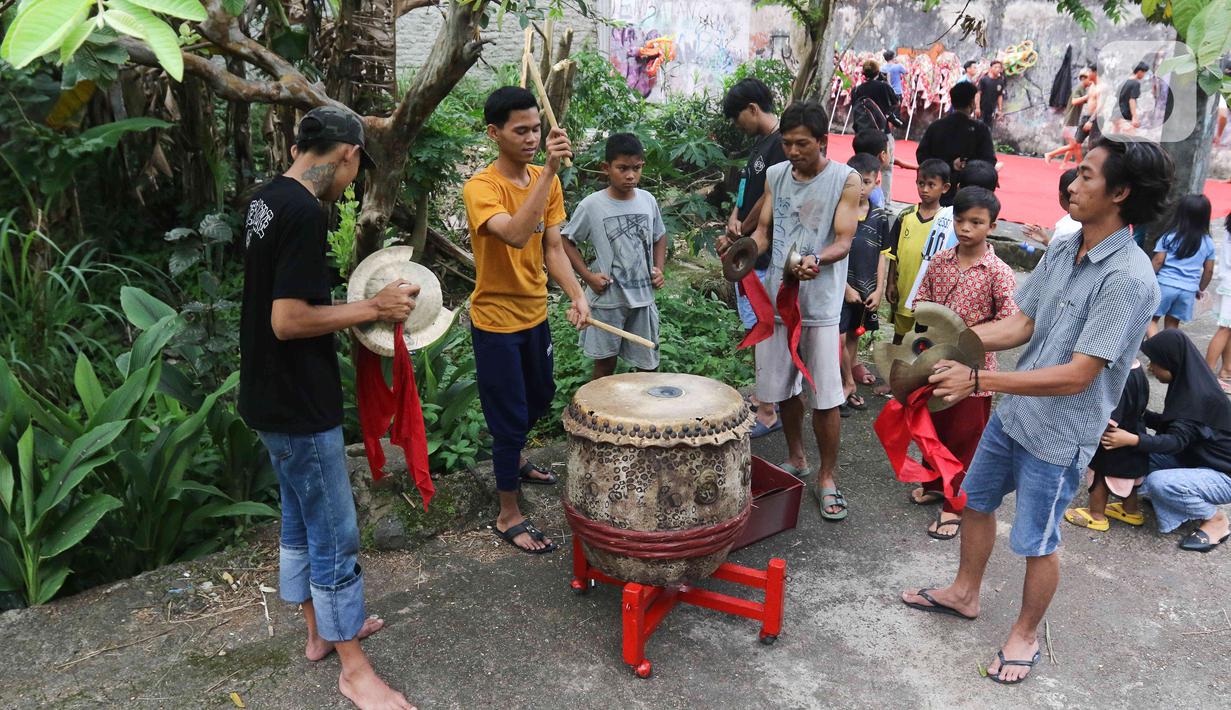 Pemain dari kelompok barongsai Naga Merah Putih Bogor melakukan pemanasan sebelum latihan dengan Barongsai dan Liong di kawasan Babakan Pasar, Kota Bogor, Jawa Barat, Rabu (11/1/2023). Latihan tersebut  untuk mempersiapkan penampilan menyambut Tahun Baru Imlek. (Liputan6.com/Herman Zakharia)