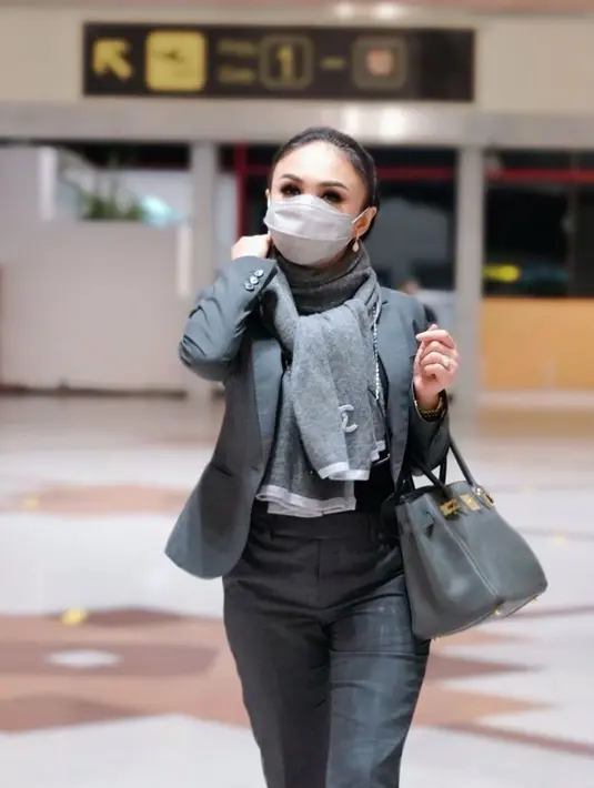 Fashion airport serba hitam yang digunakan oleh kakak Krisdayanti ini juga mendapat pujian netizen. Pasalnya, dirinya tetap terlihat menawan meski menggunakan busana serba hitam lengkap dengan masker wajah. (Liputan6.com/IG/@yunishara36)
