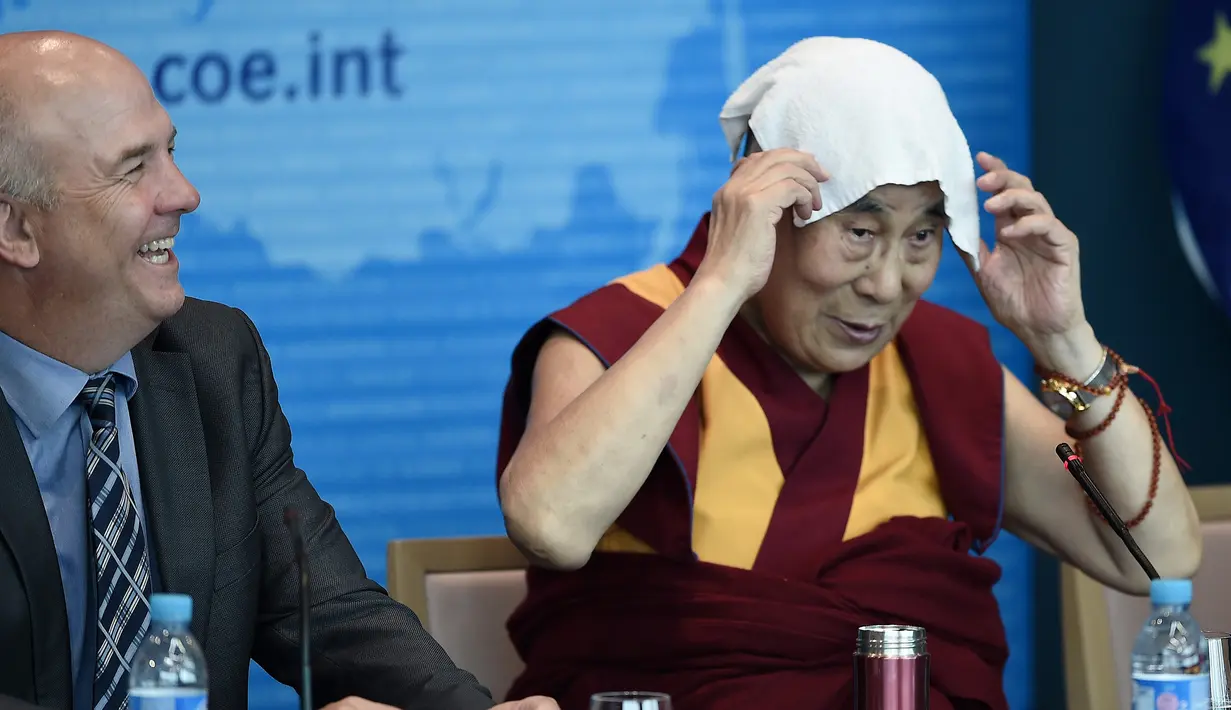Dalai Lama meletakkan sapu tangan di kepalanya saat ia pidato di Dewan Eropa di Strasbourg, Perancis, Kamis (15/9). Ini adalah kunjungan Eropa pertama Dalai Lama setelah lima tahun. (AFP PHOTO/Frederick Florin)