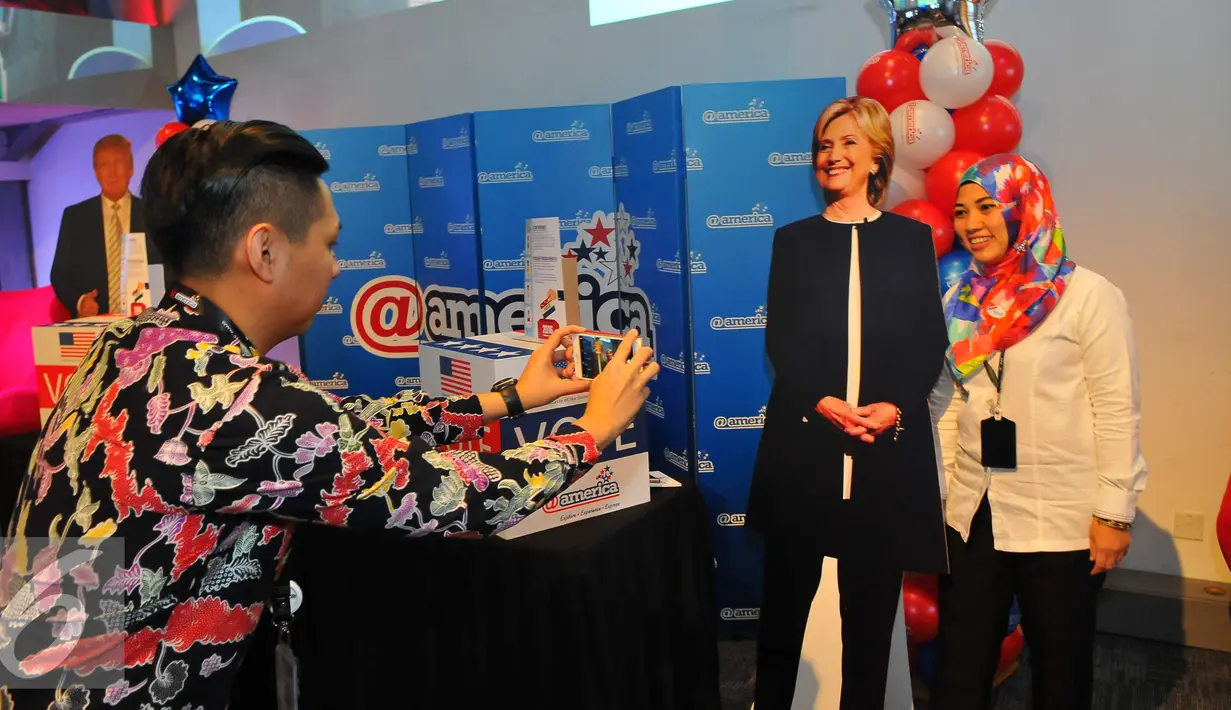 Pengunjung berfoto dengan pajangan berbentuk Hillary Clinton saat mengikuti simulasi pemilihan Presiden Amerika Serikat di @america di Jakarta, Rabu (9/11). (Liputan6.com/Angga Yuniar)