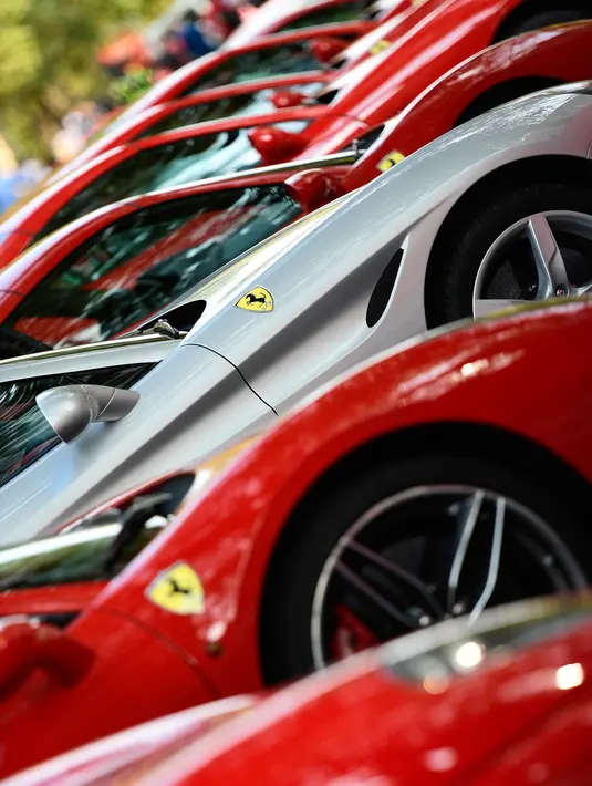 Deretan mobil asal Italia, Ferrari dipamerkan saat perayaan ulang tahun Ferrari ke-70 di Corso Sempione di Milan, Italia (8/9). Dalam acara ini sekitar 500 mobil Ferrari dari berbagai tipe pamerkan. (AFP Photo/Miguel Medina)