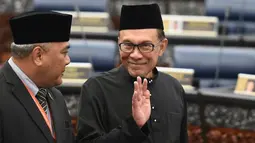 Pemimpin Partai Keadilan Rakyat Malaysia, Anwar Ibrahim melambaikan tangan sebelum mengambil sumpah jabatan dalam upacara pelantikan di Gedung Parlemen, Kuala Lumpur, Senin (15/10). Anwar Ibrahim dilantik sebagai anggota parlemen. (MOHD RASFAN/AFP)