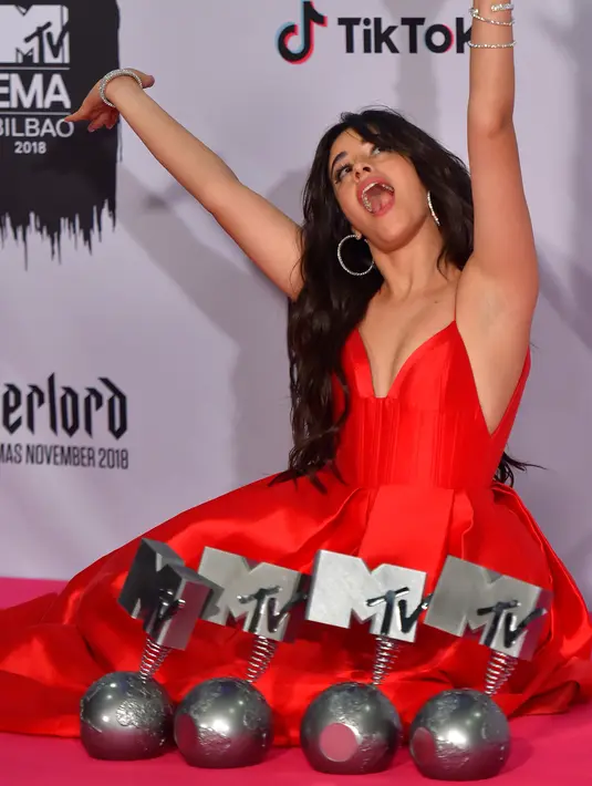 Penyanyi cantik asal Kuba, Camila Cabello berpose dengan empat penghargaan yang diraihnya selama MTV Europe Music Awards 2018 di Bizkaia Arena, Bilbao, Spanyol (4/11). (AFP Photo/Ander Gillenea)