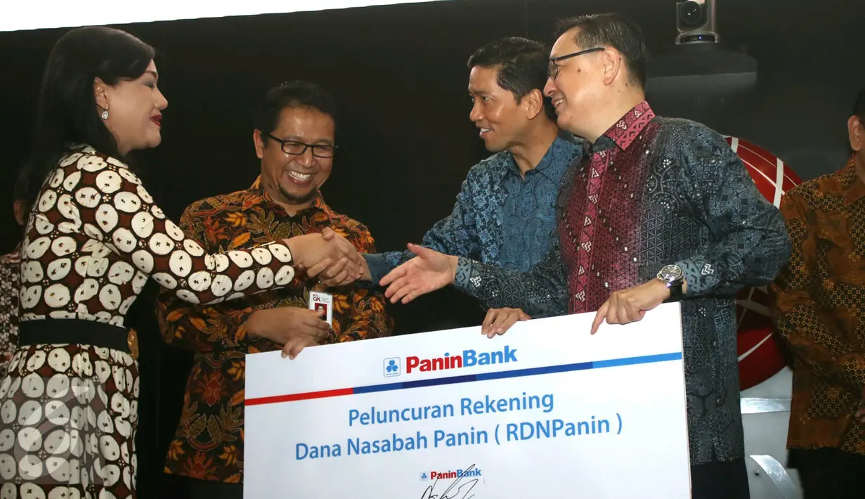 Direktur PaninBank Hendrawan Danusaputra bersalaman dengan Direktur Utama KSEI Friderica Widyasari saat peluncuran administrator RDN di Bursa Efek Indonesia, Jakarta, Rabu (5/4). (Liputan6.com/Angga Yuniar)