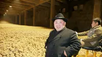 Kim Jong-un berpose di depan hamparan kentang di pabrik baru pengelolaan kentang di kota  Samjiyon (STR / KCNA VIA KNS / AFP)