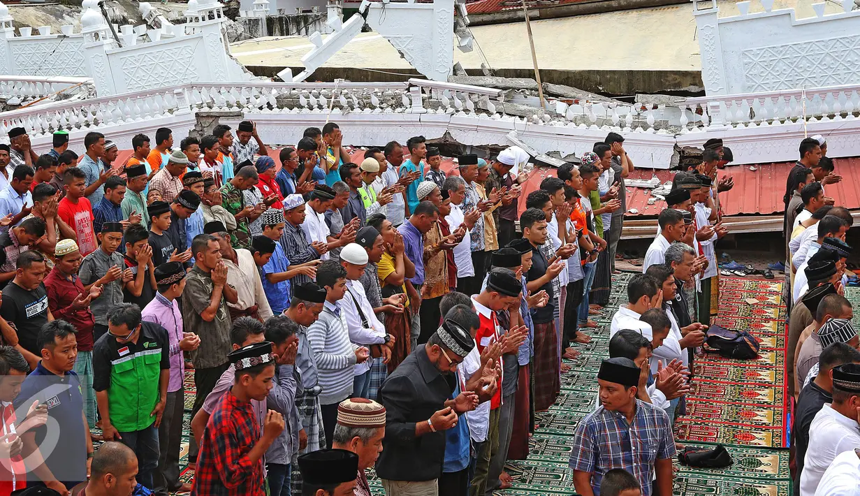 Suasana Salat Jumat warga Pidie di halaman Masjid Jami Quba, Aceh, Jumat (9/12). Gempa berkekuatan 6,5 SR telah merobohkan ratusan bangunan termasuk Masjid Jami Quba. (Liputan6.com/Angga Yuniar)