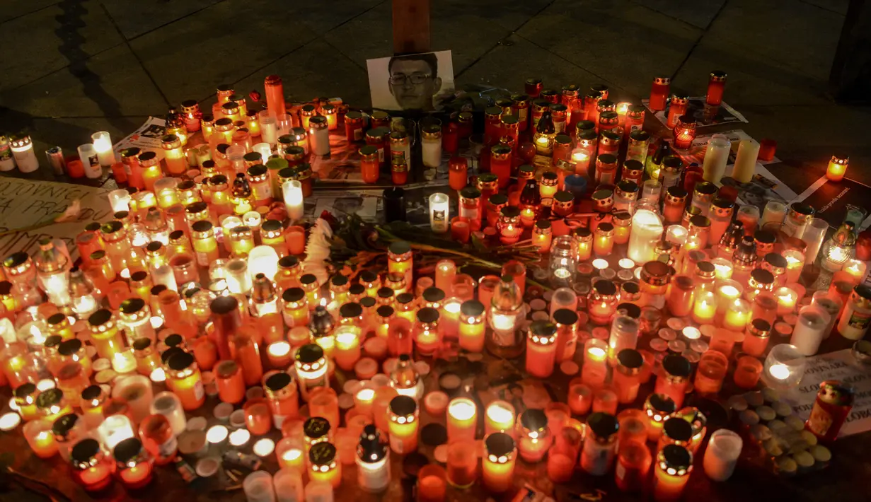 Ratusan lilin dinyalakan di depan foto jurnalis investigasi Slovakia Jan Kuciak di Wenceslas Square di Praha (26/2). Sebelumnya Jan Kuciak dan kekasihnya ditemukan tewas ditembak di rumah yang mereka tempati. (AFP Photo/Michal Cizek)