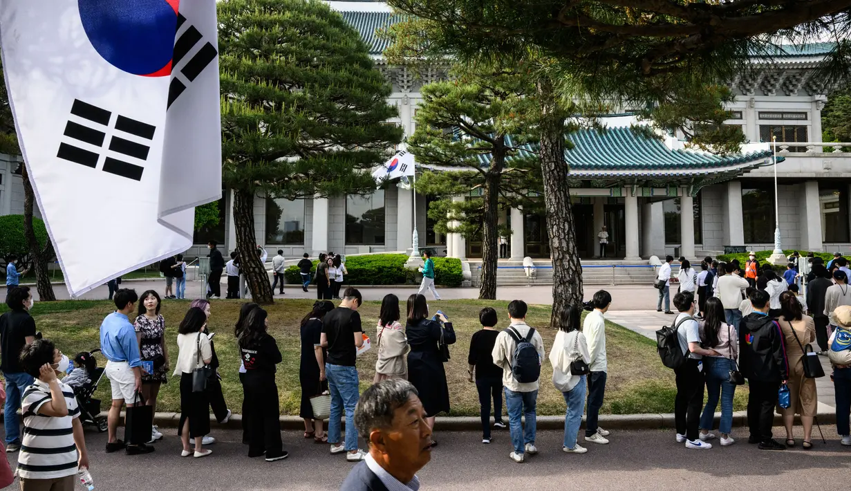 Pengunjung berbaris untuk mengambil foto di Kompleks Blue House sehari setelah dibuka untuk umum menyusul janji kampanye Presiden Korea Selatan Yoon Suk-yeol di Seoul, Korea Selatan, 11 Mei 2022. (ANTHONY WALLACE/AFP)
