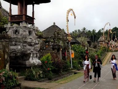 Wisatawan berjalan menyusuri kawasan Desa Penglipuran di Kabupaten Bangli, Bali, Rabu (16/8/2023). (Liputan6.com/Helmi Fithriansyah)