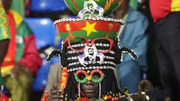 Seorang suporter Burkina Faso mengunakan atribut di kepalanya saat menyaksikan pertandingan grup A antara antara Guinea-Bissau dan Burkina Faso di Franceville pada 22 Januari 2017. (AFP Photo/Khaled Desouki)
