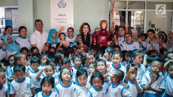Pendiri Yayasan Pansophia Nusantara, Millie Lukito foto bersama guru dan anak-anak Pendidikan anak usia dini (PAUD) Cahaya Permata Indonesia (CPI) di Rusunawa Marunda, Jakarta Utara, Jumat (30/11). (Liputan6.com/Faizal Fanani)