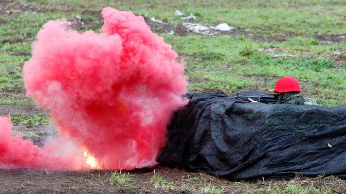 Seorang tentara bersembunyi saat latihan militer di Hualien, Taiwan timur, (30/1). Militer Taiwan memulai latihan gabungan dua hari untuk menunjukkan tekadnya untuk mempertahankan diri dari ancaman China. (AP Photo/Chiang Ying-ying)