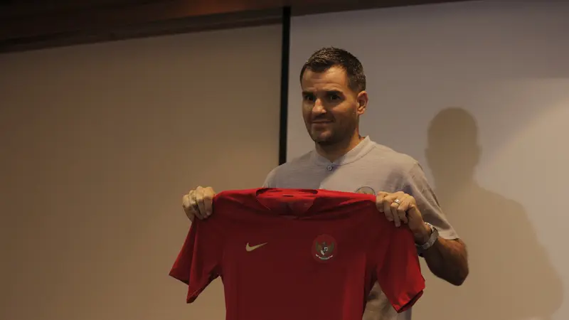 Pelatih Timnas Indonesia, Simon McMenemy, memegang jersey saat jumpa pers. (Bola.com/Okie Prabhowo)