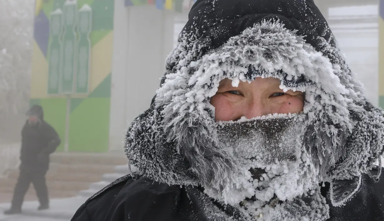 Seorang pria menatap fotografer yang sedang berjalan di jalan saat suhu turun hingga sekitar -50 derajat (-58 derajat Fahrenheit) di Yakutsk, Rusia pada Rusia, Sabtu (16/1/2021).  Yakutsk atau Yakutia tersohor sebagai kota terdingin di dunia. (AP Photo/Ajar Warlamov)