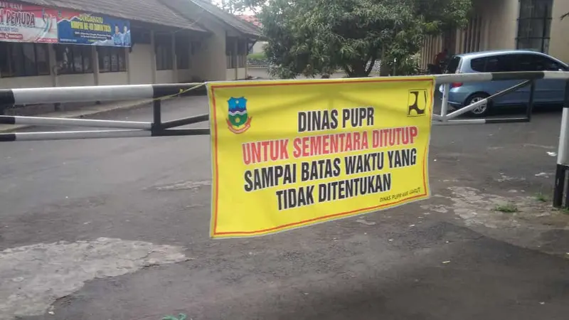 Nampak sebuah poster pengumuman penutupan Kantor Dinas PUPR Garut, Jawa Barat, akibat salah seorang pejabatnya positif terpapar Covid-19.