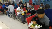Rombongan Sriwijaya FC menikmati makanan di ruang tunggu bandara sembari menunggu penerbangan ke Surabaya, Minggu (30/8/2015) malam. (Bola.com/Riskha Prasetya)