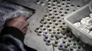 Seorang pekerja membuat mata boneka seks di pabrik EXDOLL, sebuah perusahaan yang terletak di Dalian, China, Kamis (1/2). EXDOLL menciptakan bonek seks pintar. (AFP PHOTO/FRED DUFOUR)