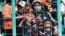 Suporter Cilik saat menyaksikan pertandingan Persija Jakarta melawan Arema FC pada laga BRI Liga 1 di Stadion Patriot Candrabhaga, Bekasi, Minggu (12/2/2023). Orang tua yang juga fans Persija sudah mulai menularkan kecintaan mereka pada Macan Kemayoran sejak dini. (Bola.com/M Iqbal Ichsan)