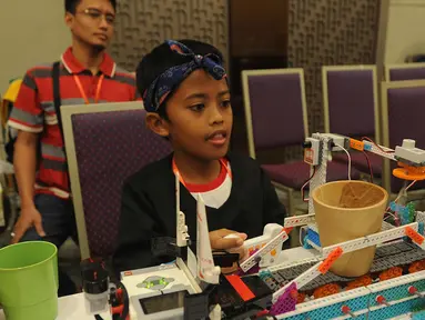 Murid SD mengoperasikan robot hasil kreatifitasnya berupa robot pembuat teh saat kegiatan Indonesian Youth Robot Competititon  di ICE, BSD, Tangerang Selatan (22/4). Kegiatan ini diikuti ribuan murid TK-SMA untuk keempat kalinya. (Merdeka.com/Arie Basuki)