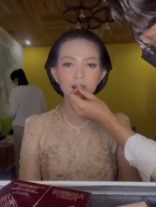 Sang MUA pun mulai mengaplikasikan lipstik yang dimulai dari bagian bawah bibir Selvi. Dan dipoles secara merata hingga bibir bawah tampak bervolume. [@antoniusanungmakeup]