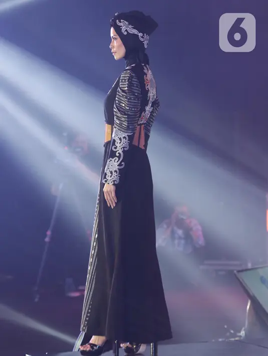 Seorang model berpose membawakan busana rancangan Wignyo saat peragaan busana dalam gelaran Festival 6 2023 di Senayan Park, Jakarta, Minggu (9/7/2023). (Liputan6.com/Helmi Fithriansyah)