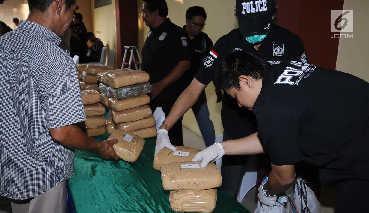 Petugas memasukkan barang bukti 225 kg ganja saat rilis di RS Polri Kramat Jati Jakarta, Rabu (30/8). Satresnarkoba Polda Metro Jaya menggagalkan peredaran 225 kg ganja asal Aceh serta menangkap satu tersangka. (Liputan6.com/Helmi Fithriansyah)