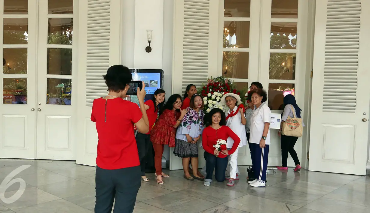 Warga berfoto di teras pendopo Balai Kota DKI Jakarta, Selasa (9/5). Ada yang berbeda dari Balai Kota pagi ini, Gubernur DKI Basuki Tjahaja Purnama atau Ahok tidak ke Balai Kota terlebih dulu menjelang sidang pembacaan putusan. (Liputan6.com/Johan Tallo)