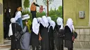 Anak perempuan tiba setelah sekolah mereka dibuka kembali di Kabul, Rabu (23/3/2022). Pembukaan kembali sekolah menengah untuk anak perempuan di seluruh Afghanistan memicu kegembiraan dan ketakutan puluhan ribu siswa yang kehilangan pendidikan sejak Taliban kembali berkuasa. (Ahmad SAHEL ARMAN/AFP)