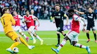 Striker Arsenal, Bukayo Saka, berusaha membobol gawang Eintracht Frankfurt pada laga Europa League di Frankfurt, Kamis (19/9). Frankfurt kalah 0-3 dari Arsenal. (AFP/Uwe Anspach)
