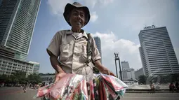 Pedagang parasut mainan menjajakan dagangannya di kawasan Bundaran HI, Jakarta, Minggu (22/3/2015).  Seiring dengan perkembangan zaman dan modernisasi, permainan tradisional kini mulai tergantikan. (Liputan6.com/Faizal Fanani)