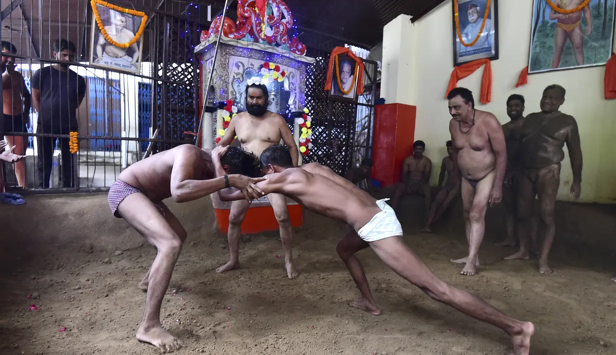Pegulat beraksi dalam pertandingan gulat tradisional di klub gulat Loknath Vyayamsala di Prayagraj, India, (21/8/2023). Acara tersebut untuk merayakan festival Hindu Nag Panchami. (AFP/Sanjay kanojia)